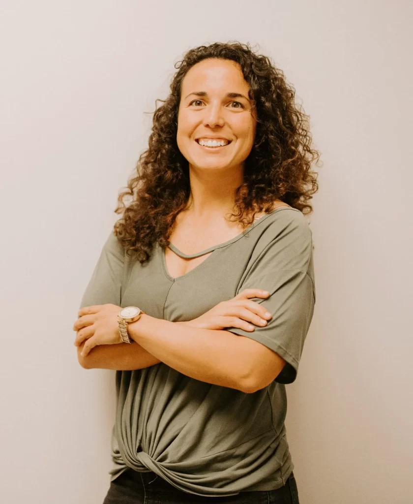 A Profile picture of Dr. Hallie Elchos standing in front of a plain wall